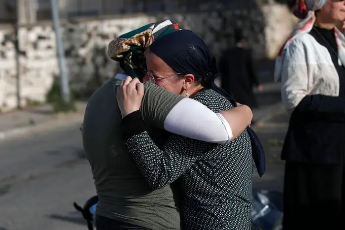 A woman cries and hugs another mourner during a funeral of a man who died in the deadly  Lag b’Omer event in Mount Meron